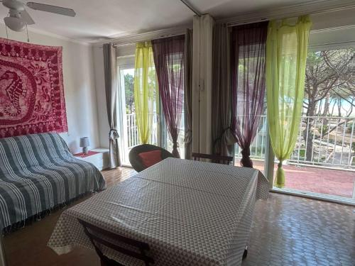 - un salon avec une table, un canapé et des fenêtres dans l'établissement Appartement 2 pièces 5 couchages ARGELES SUR MER AR630-005, à Argelès-sur-Mer