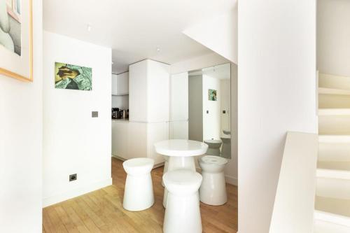 - une salle de bains blanche avec 2 toilettes et un miroir dans l'établissement Musée d'Orsay-Saint Germain-Invalides-Famille, à Paris