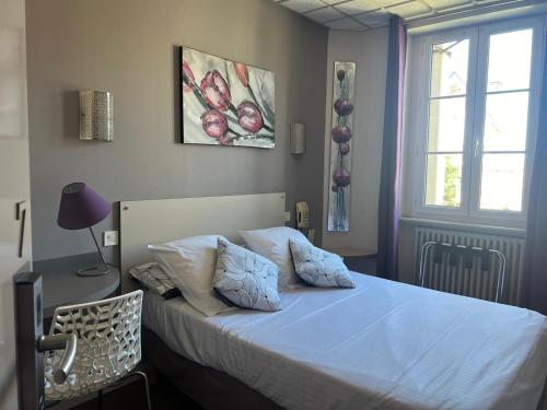 a bedroom with a bed with white sheets and a window at L'Artimon by les Ambassadeurs - Saint Malo Plage in Saint Malo