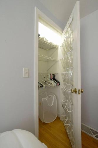 a room with a closet with glass shelves and a door at Coastal Haven in West Dennis in Dennis
