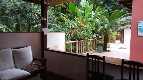 a porch with a chair and some plants at Pitanga Ilha Grande in Abraão