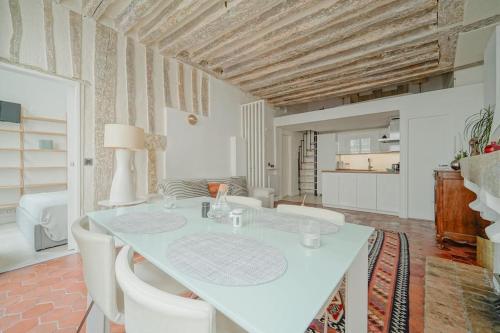 une salle à manger avec une table blanche et des chaises blanches dans l'établissement 2 BR with the Best Location of Paris in 2nd Arr, à Paris