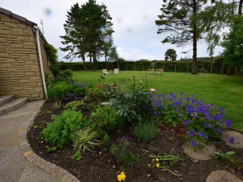 a garden with flowers and a park in the background at 6 Bed in South Queensferry 94359 in Broxburn
