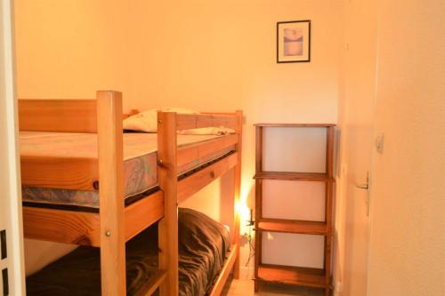 Cette chambre comprend 2 lits superposés et une étagère. dans l'établissement Appartement Studio cabine 4 couchages ARGELES SUR MER AR070-408, à Argelès-sur-Mer