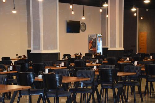 a dining room with tables and chairs and a tv at MyFlower 3 Hotel in Erbil