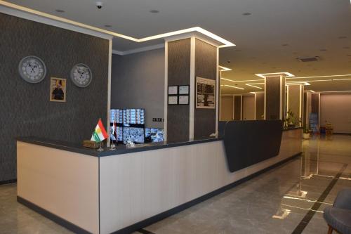 a lobby with a counter with clocks on the wall at MyFlower 3 Hotel in Erbil