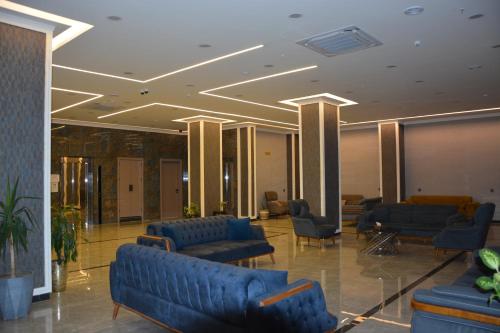 a lobby with blue couches and chairs in a building at MyFlower 3 Hotel in Erbil
