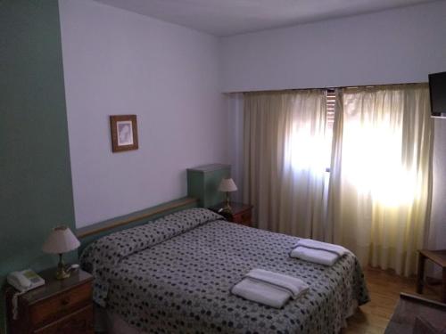 a bedroom with a bed with two towels on it at Hotel Chapelco Ski in San Martín de los Andes