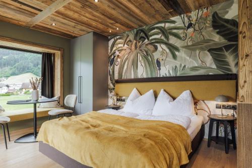 a bedroom with a large bed with a large painting on the wall at Zellrooms in Zell am Ziller