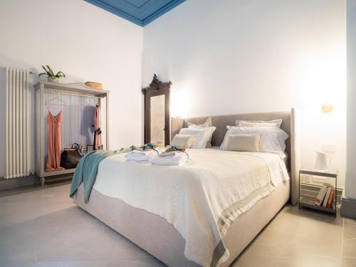 una camera da letto con un grande letto bianco con asciugamani sopra di Palazzo Santa Ninfa - Luxury Mansion a Palermo