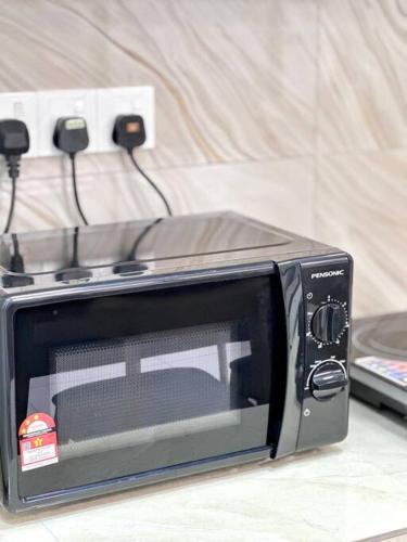 a microwave oven sitting on top of a counter at URBAN Georgetown 9Pax 4QueenBed 3Bedroom 2Bath 2carparks in Jelutong