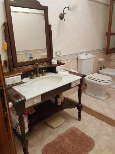 une salle de bain avec un lavabo et un miroir et des toilettes dans l'établissement La terrazza sulle Eolie, à Capo dʼOrlando