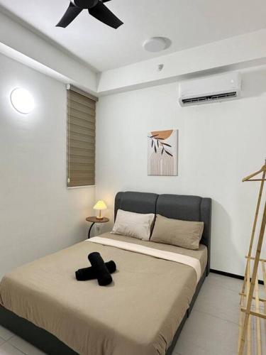 a bedroom with a bed with a black bow tie on it at URBAN Georgetown 9Pax 4QueenBed 3Bedroom 2Bath 2carparks in Jelutong