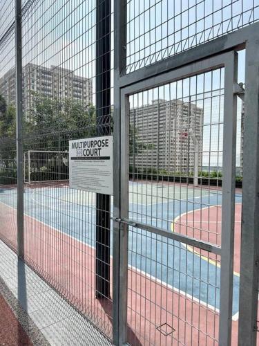 a tennis court behind a fence with a sign on it at URBAN Georgetown 9Pax 4QueenBed 3Bedroom 2Bath 2carparks in Jelutong