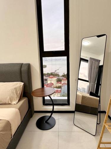 a room with a bed and a table and a mirror at URBAN Georgetown 9Pax 4QueenBed 3Bedroom 2Bath 2carparks in Jelutong
