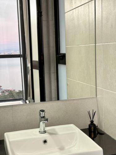 a bathroom with a white sink and a mirror at URBAN Georgetown 9Pax 4QueenBed 3Bedroom 2Bath 2carparks in Jelutong