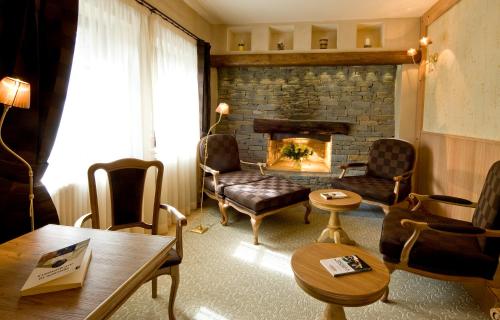 a living room with a fireplace and chairs and a table at Maison Cly in Chamois