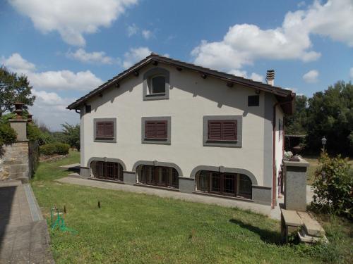 a large white building with windows on a yard at Il Rifugio del Vescovo in Vetralla