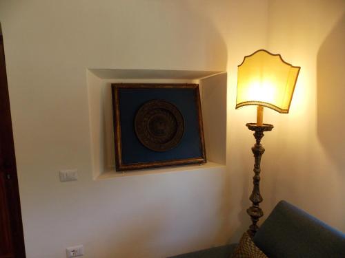 a lamp in a room with a picture on the wall at Il Rifugio del Vescovo in Vetralla