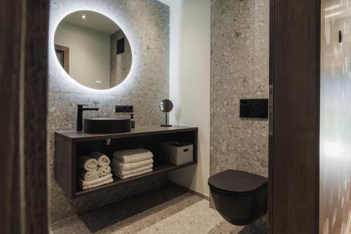 a bathroom with a sink and a toilet and a mirror at Zellrooms in Zell am Ziller