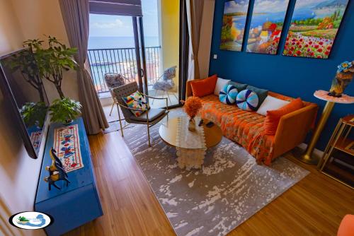 a living room with an orange couch and a table at Oscar Seaview Apartment in Phu Quoc