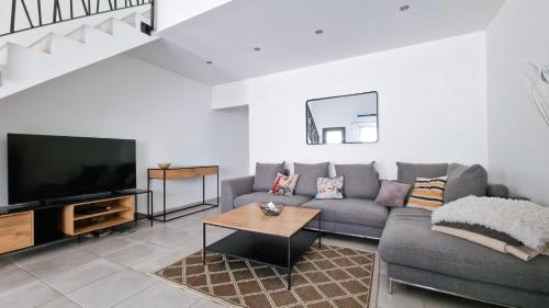 un salon avec un canapé et une télévision dans l'établissement APPARTEMENT PLEIN CENTRE, à Bernis