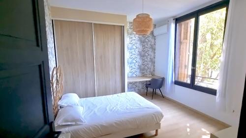 une chambre avec un lit et une fenêtre dans l'établissement Maison de caractère en plein cœur de la Provence, à Avignon