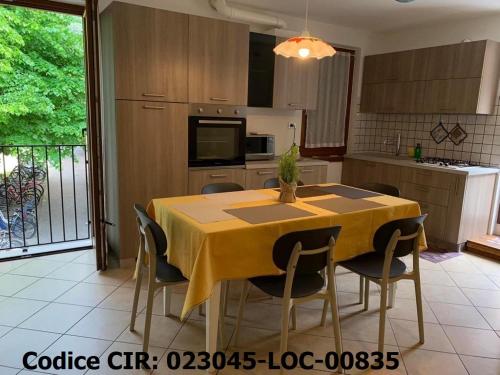 a kitchen with a yellow table and chairs in it at Hotel Dolomiti in Malcesine