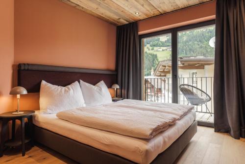a bedroom with a bed and a large window at Zellrooms in Zell am Ziller