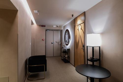 a hallway with a chair and a table and a door at 163 BOUTIQUE HOTEL in Rome