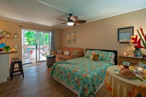 a bedroom with a bed and a living room at Sandpiper 120B in Princeville
