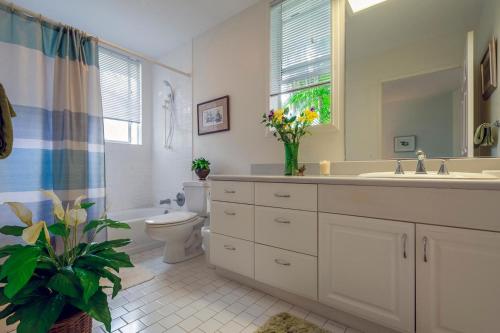 a bathroom with a sink and a toilet and a mirror at Emmalani Court 411 in Princeville