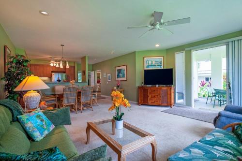 a living room with a couch and a table with a tv at Emmalani Court 411 in Princeville