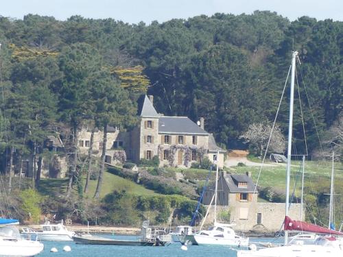 a large house with boats docked in a harbor at Appartement Pont l'Abbé Entre océan et campagne in Pont-lʼAbbé