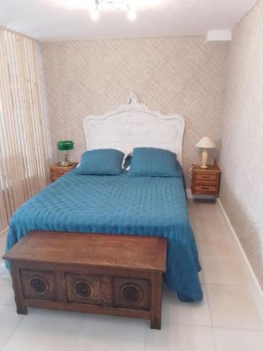 une chambre avec un lit avec une couette bleue dans l'établissement Appartement Pont l'Abbé Entre océan et campagne, à Pont-lʼAbbé