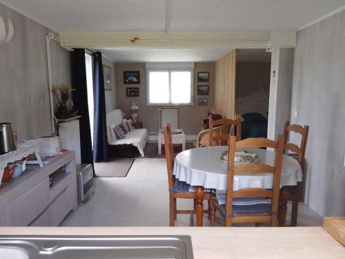 une cuisine et une salle à manger avec une table et des chaises dans l'établissement Appartement Pont l'Abbé Entre océan et campagne, à Pont-lʼAbbé