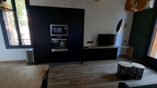 un salon avec une télévision, une table et des chaises dans l'établissement Maison de caractère en plein cœur de la Provence, à Avignon