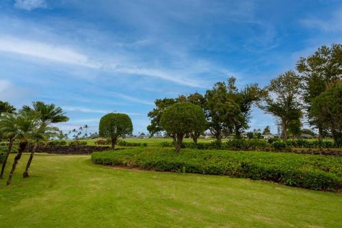 a park with trees and grass and bushes at Emmalani Court 411 in Princeville