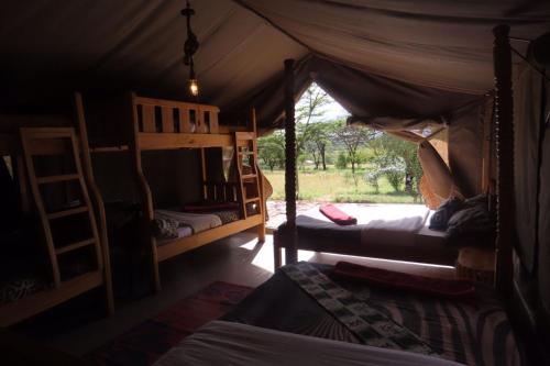 a bedroom with two bunk beds in a tent at Oseki Maasai Mara Camp in Narok