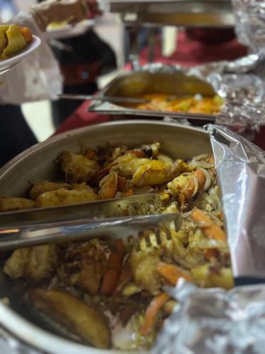 una tavola con una padella di cibo su un tavolo di MOON RUM lUXURY CAMP a Wadi Rum