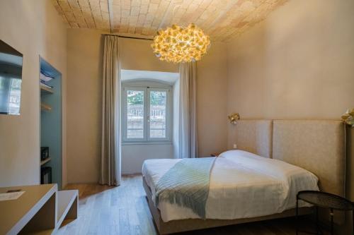 a bedroom with a bed and a chandelier at 163 BOUTIQUE HOTEL in Rome
