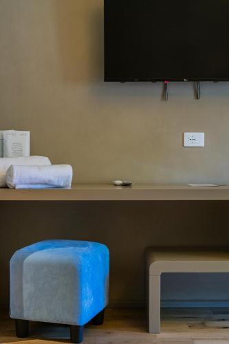 a table with a blue stool and a tv on a wall at 163 BOUTIQUE HOTEL in Rome