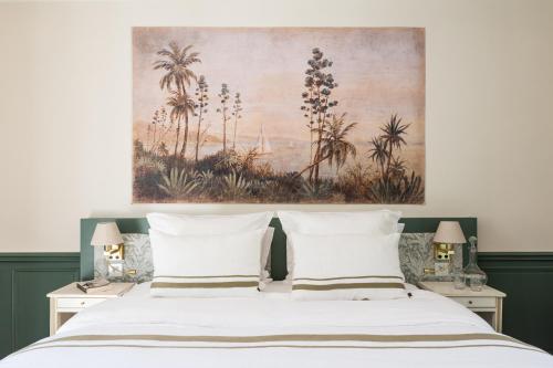 a bedroom with a bed with a painting above it at La Maison 1680 in Couches