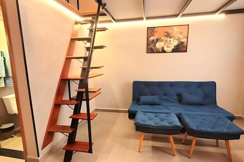 a room with a blue ottoman and a ladder at Laguna Lofts in Poços de Caldas