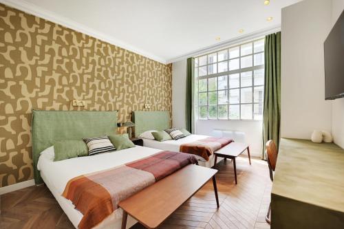 une chambre avec deux lits et une fenêtre dans l'établissement Amazing appartement - 3BR-10P - Saint Germain, à Paris