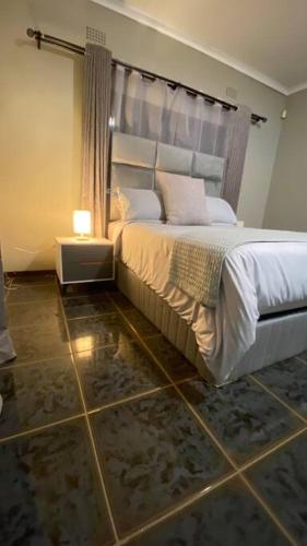a bedroom with a bed and a tiled floor at 3 Beds Urban Escape Home in Gaborone