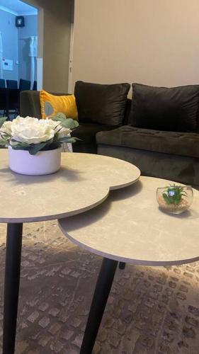 two tables in a living room with a couch at 3 Beds Urban Escape Home in Gaborone