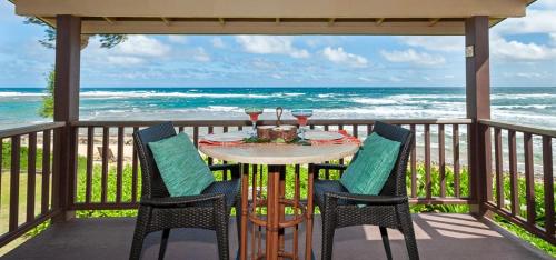 a table and chairs on a balcony with the ocean at Hanalei Colony Resort F3 in Hanalei