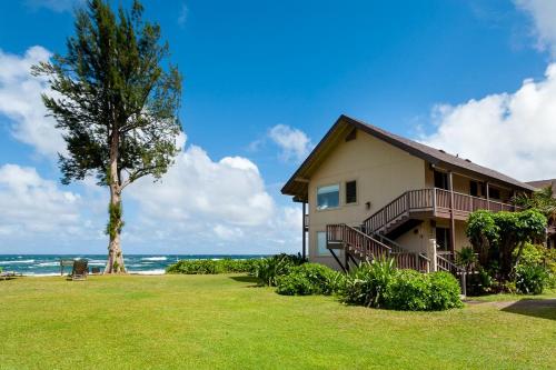 a house with a tree next to the ocean at Hanalei Colony Resort F3 in Hanalei