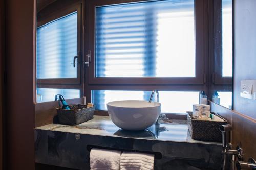 a bathroom with a bowl sink on a counter with windows at 163 BOUTIQUE HOTEL in Rome